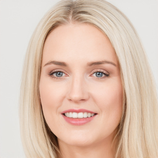 Joyful white young-adult female with long  brown hair and blue eyes