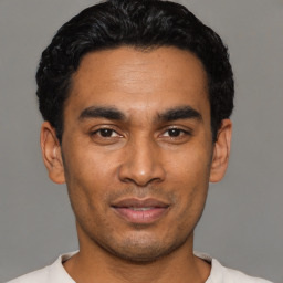 Joyful latino young-adult male with short  black hair and brown eyes