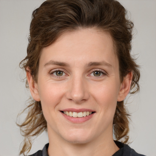 Joyful white young-adult female with medium  brown hair and green eyes