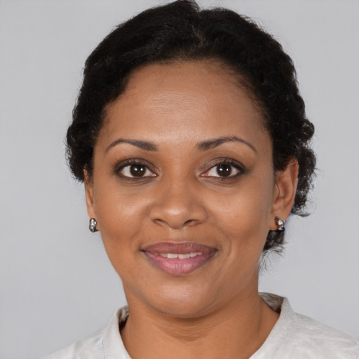Joyful black adult female with short  black hair and brown eyes