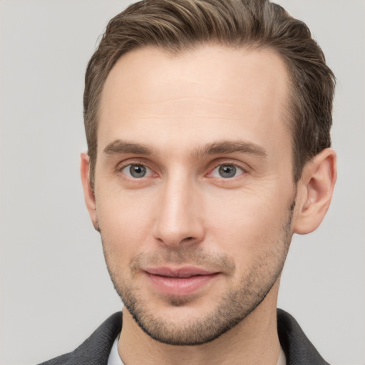 Joyful white young-adult male with short  brown hair and grey eyes