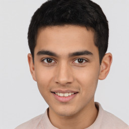 Joyful latino young-adult male with short  brown hair and brown eyes