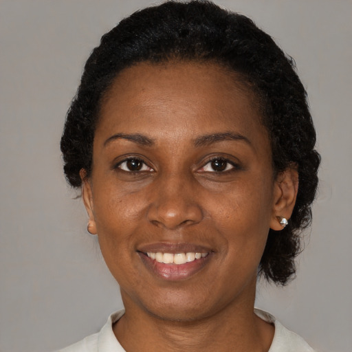 Joyful black adult female with short  black hair and brown eyes