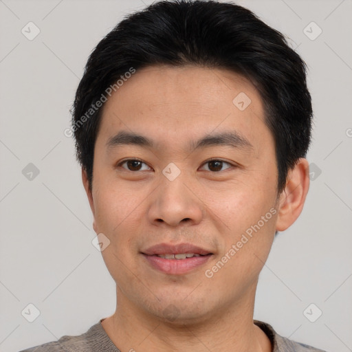 Joyful asian young-adult male with short  black hair and brown eyes