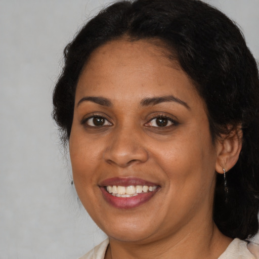 Joyful black adult female with medium  brown hair and brown eyes