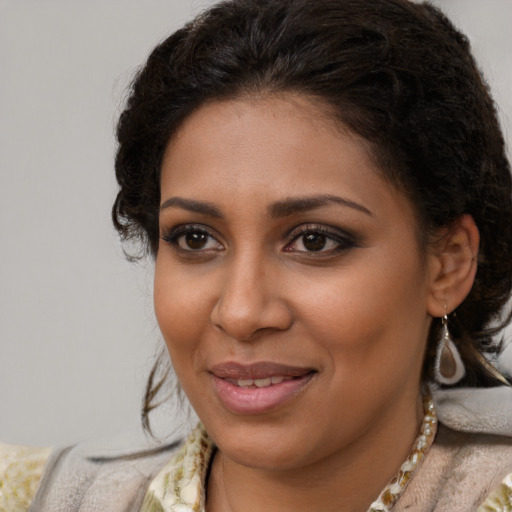 Joyful black young-adult female with medium  brown hair and brown eyes