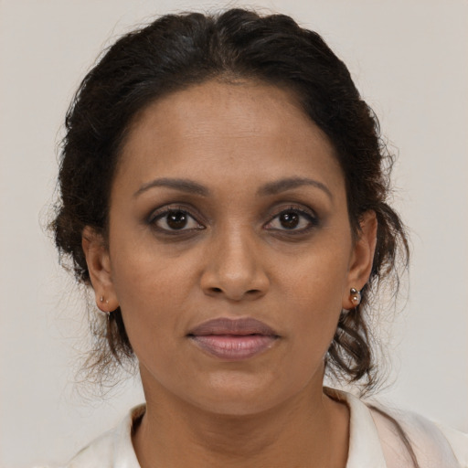 Joyful black young-adult female with long  brown hair and brown eyes