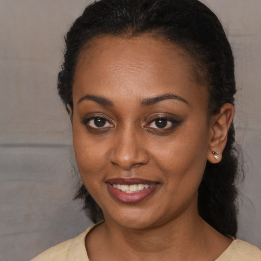 Joyful black young-adult female with medium  brown hair and brown eyes