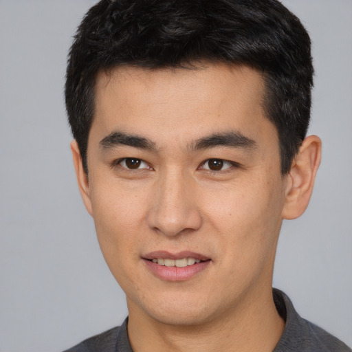 Joyful asian young-adult male with short  brown hair and brown eyes