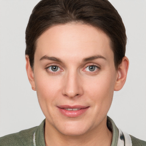 Joyful white young-adult female with short  brown hair and grey eyes