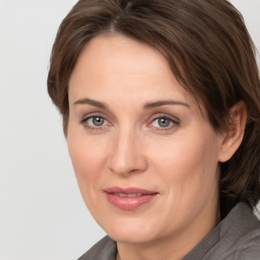 Joyful white adult female with medium  brown hair and grey eyes