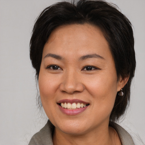 Joyful asian adult female with medium  brown hair and brown eyes