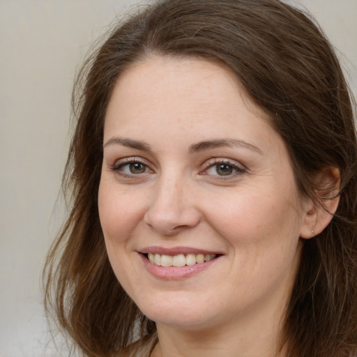 Joyful white adult female with long  brown hair and brown eyes