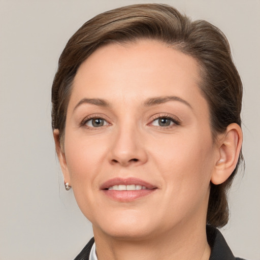 Joyful white young-adult female with medium  brown hair and grey eyes