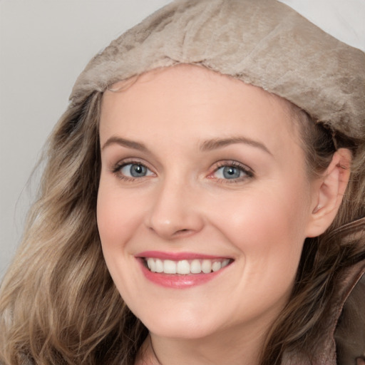 Joyful white young-adult female with long  brown hair and blue eyes