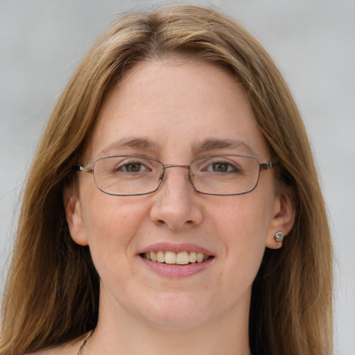 Joyful white adult female with long  brown hair and blue eyes