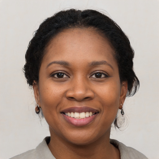 Joyful black young-adult female with medium  black hair and brown eyes