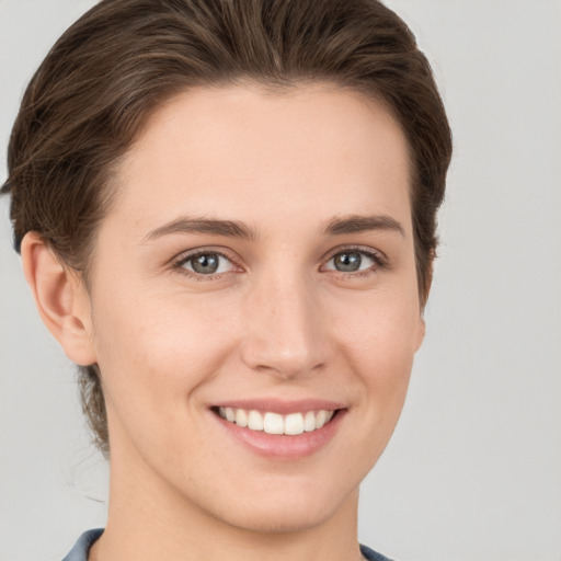 Joyful white young-adult female with short  brown hair and grey eyes