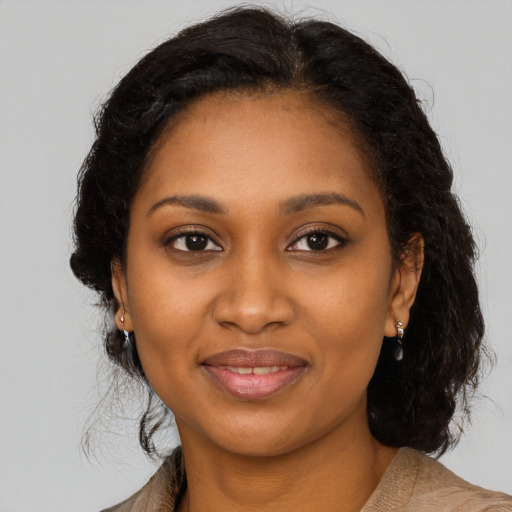 Joyful black young-adult female with long  brown hair and brown eyes