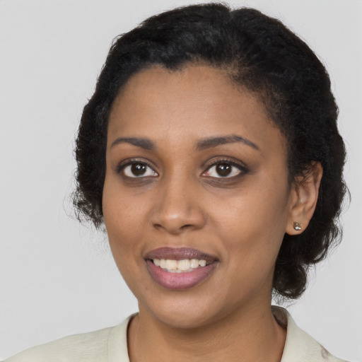 Joyful black young-adult female with medium  black hair and brown eyes