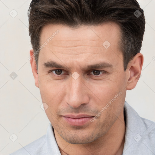 Joyful white adult male with short  brown hair and brown eyes