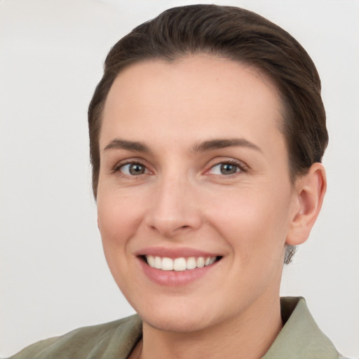 Joyful white young-adult female with short  brown hair and grey eyes