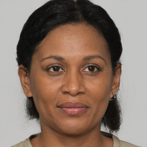 Joyful black adult female with medium  brown hair and brown eyes
