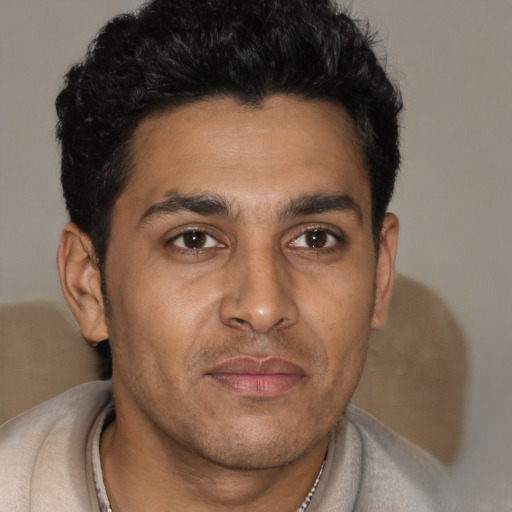 Joyful latino young-adult male with short  brown hair and brown eyes