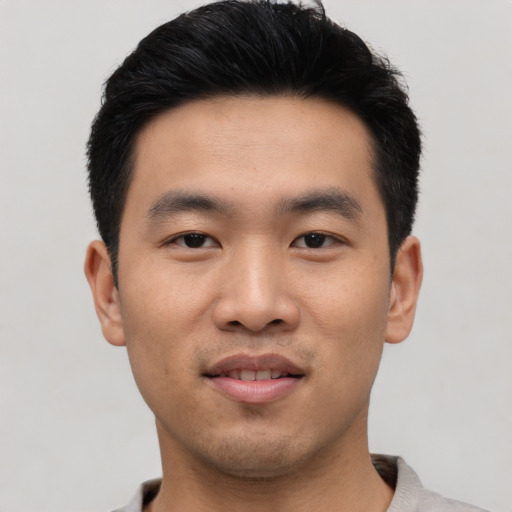 Joyful asian young-adult male with short  black hair and brown eyes