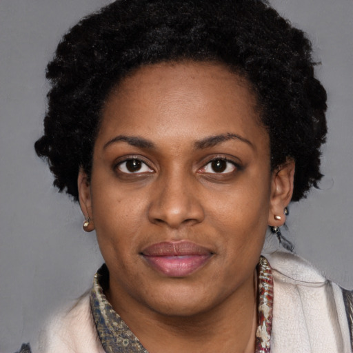 Joyful black young-adult female with short  black hair and brown eyes