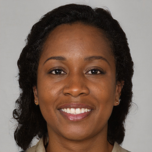 Joyful black adult female with medium  brown hair and brown eyes