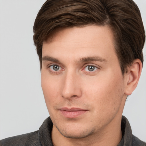 Joyful white young-adult male with short  brown hair and grey eyes