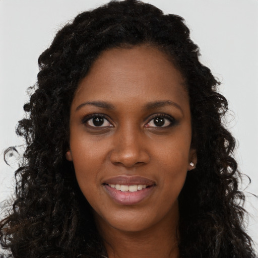 Joyful black young-adult female with long  black hair and brown eyes
