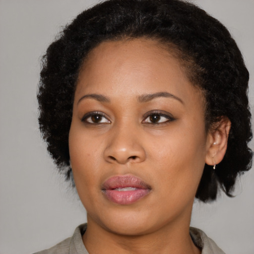 Joyful black young-adult female with medium  black hair and brown eyes