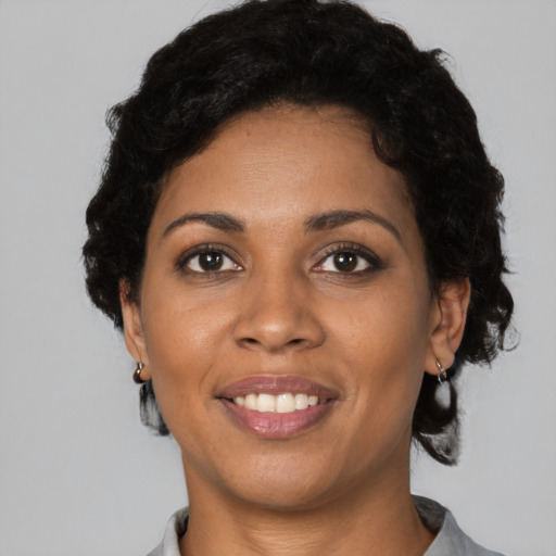 Joyful black young-adult female with short  black hair and brown eyes