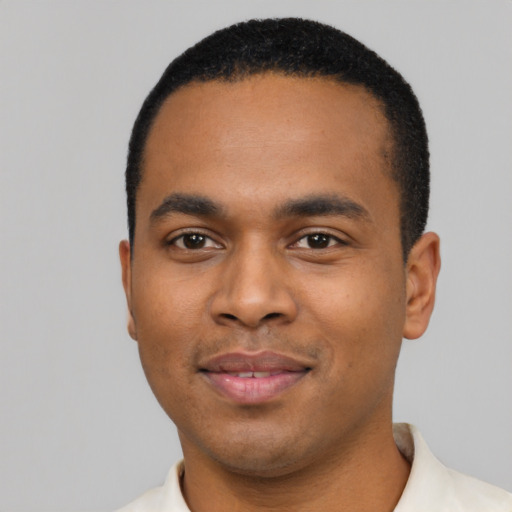 Joyful black young-adult male with short  black hair and brown eyes
