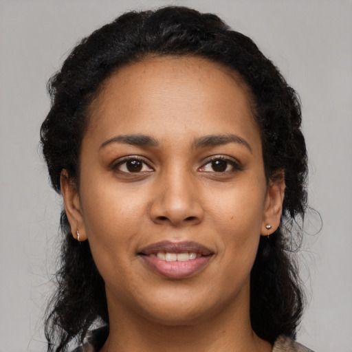 Joyful black young-adult female with long  black hair and brown eyes