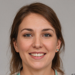 Joyful white young-adult female with medium  brown hair and grey eyes