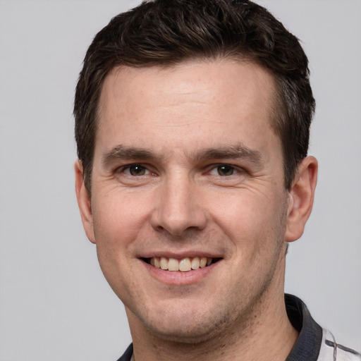 Joyful white adult male with short  brown hair and grey eyes