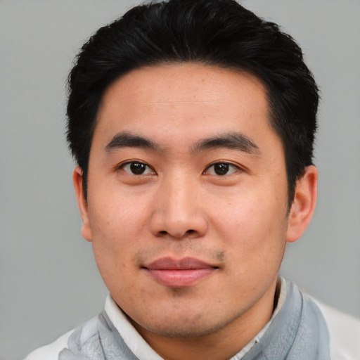 Joyful asian young-adult male with short  black hair and brown eyes