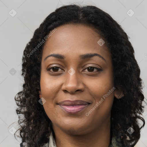 Joyful black young-adult female with long  brown hair and brown eyes