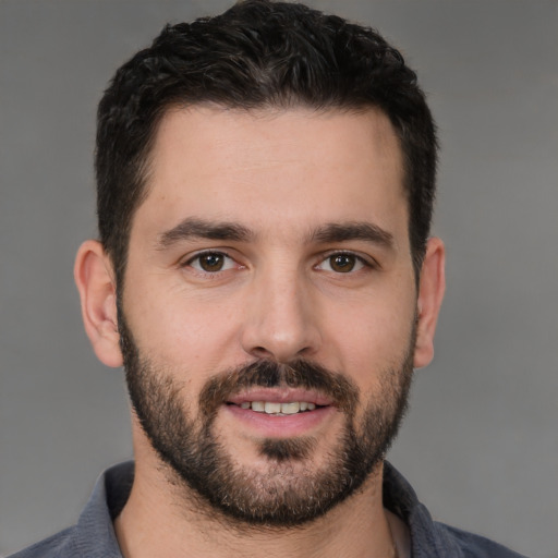 Joyful white young-adult male with short  black hair and brown eyes