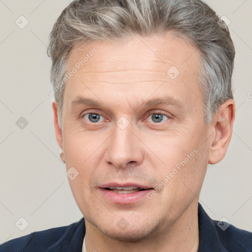 Joyful white adult male with short  brown hair and grey eyes