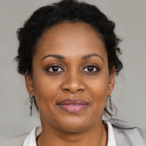 Joyful black adult female with medium  brown hair and brown eyes