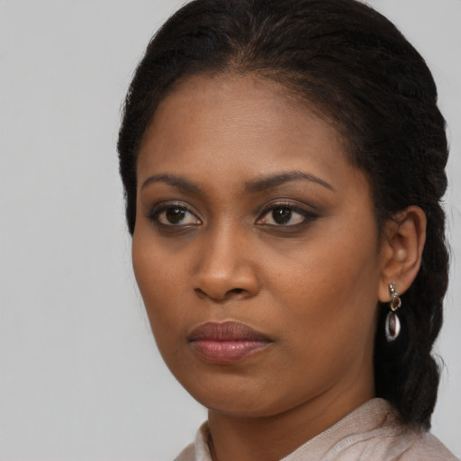 Joyful black young-adult female with long  brown hair and brown eyes