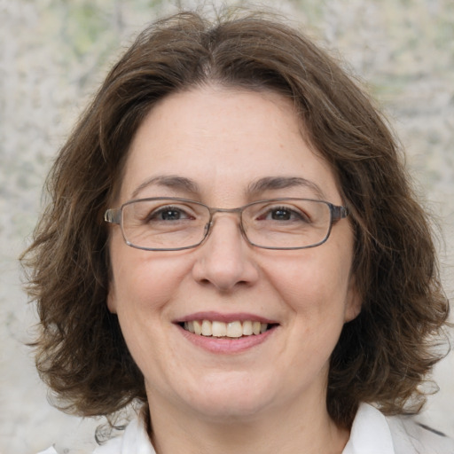 Joyful white adult female with medium  brown hair and green eyes