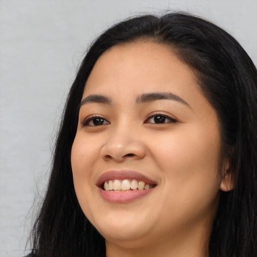 Joyful asian young-adult female with long  black hair and brown eyes