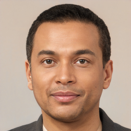 Joyful latino young-adult male with short  black hair and brown eyes