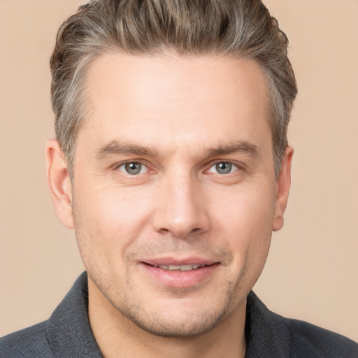 Joyful white adult male with short  brown hair and grey eyes