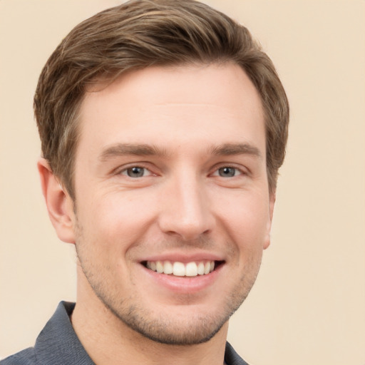 Joyful white young-adult male with short  brown hair and grey eyes